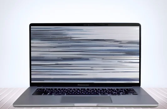 Laptop with broken screen indoors, highlighting damage and the need for laptop screen repair service.